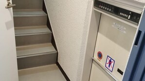 En trappa med en vägg som har en tydlig struktur och en kontrollpanel med en varningsskylt.