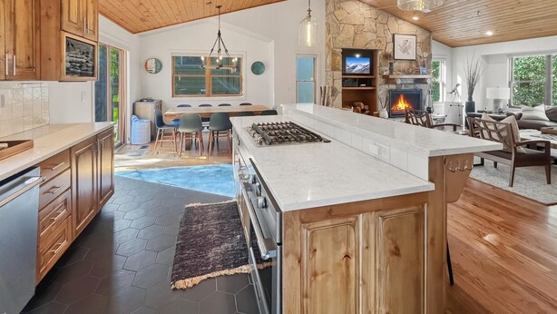 A spacious kitchen with a large island, wooden cabinets, and a stone accent wall. - Family-Friendly 5BR | Gather, Relax & Explore (Park City)