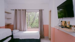 A bedroom with two beds, a TV, a window with curtains, and a shelf with items. - Dilla House  (Cartagena)
