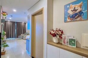 Un espace d’accueil d’hôtel comprenant un comptoir, une œuvre d’art encadrée représentant un chien, un vase avec des fleurs et un panneau d’affichage où sont accrochées des brochures.