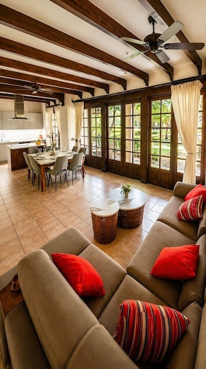 Un amplio espacio de sala con un sofá, una mesa de comedor y una cocina al fondo.