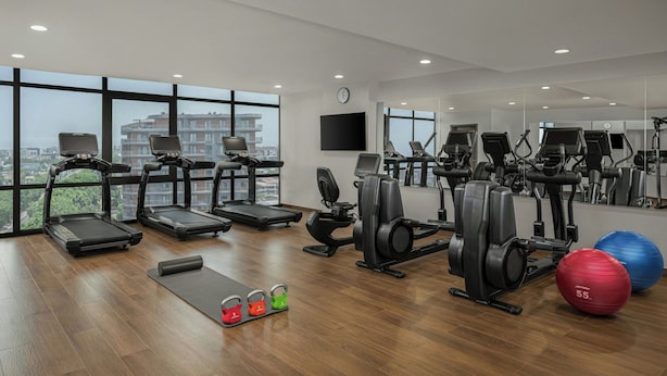 A gym with treadmills, elliptical machines, a rowing machine, and exercise balls. - Four Points® by Sheraton Accra Airport Hotel (Accra)