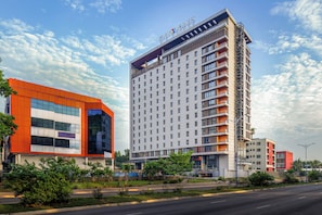 A modern hotel with a prominent orange facade, multiple floors, and balconies. - Four Points® by Sheraton Accra Airport Hotel (Accra)
