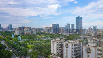 A cityscape with high-rise buildings, a mix of modern and traditional architecture, and a green park area.
