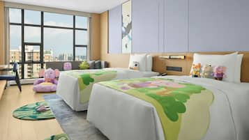 Habitación de hotel con dos camas, ventanas amplias, vista a la ciudad y peluches en las camas.