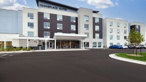 A hotel with a modern design, featuring a covered entrance and multiple floors.