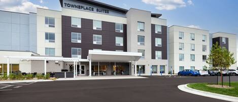 A hotel with a modern design, featuring a covered entrance and multiple floors.