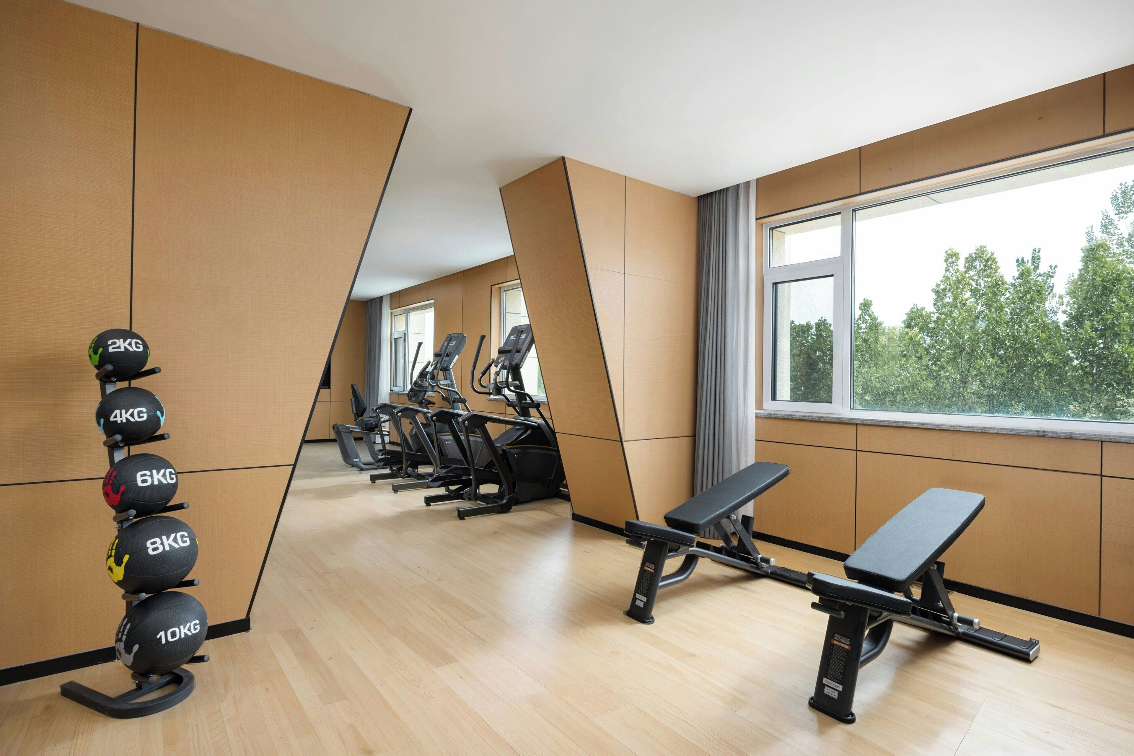 Une salle de sport équipée de machines d’exercice, d’un banc et d’une pile de poids.