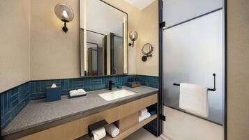 Un baño moderno con un espejo grande, dos luces empotradas, un lavamanos y una cabina de ducha de vidrio.