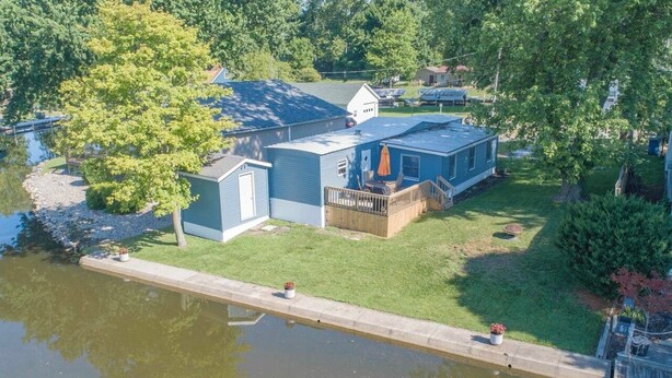 A lakeside property with a dock, a small shed, and a house with a deck. - Cozy 1-bedroom mobile home on the beautiful Crooked lake (Angola)