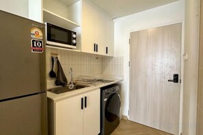 Cocina compacta equipada con microondas, lavaplatos y pileta.