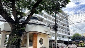 A building with a sign reading 'KREMA,' a tree in front, and a parked car.
