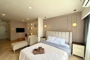 A modern hotel room with a large bed, bedside tables, a TV, and a bench. - 1B1B Classic & Cozy Room on Nimman15/Hi-Speed WIFI (Chiang Mai)