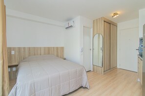 Une chambre à coucher avec un lit, une armoire et un miroir.