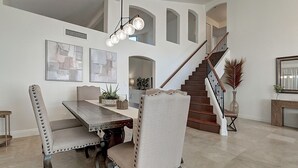 A dining area with a wooden table and upholstered chairs, a staircase, and a fireplace. - Fabulous 4-bedroom house with pool in Scottsdale (Scottsdale)