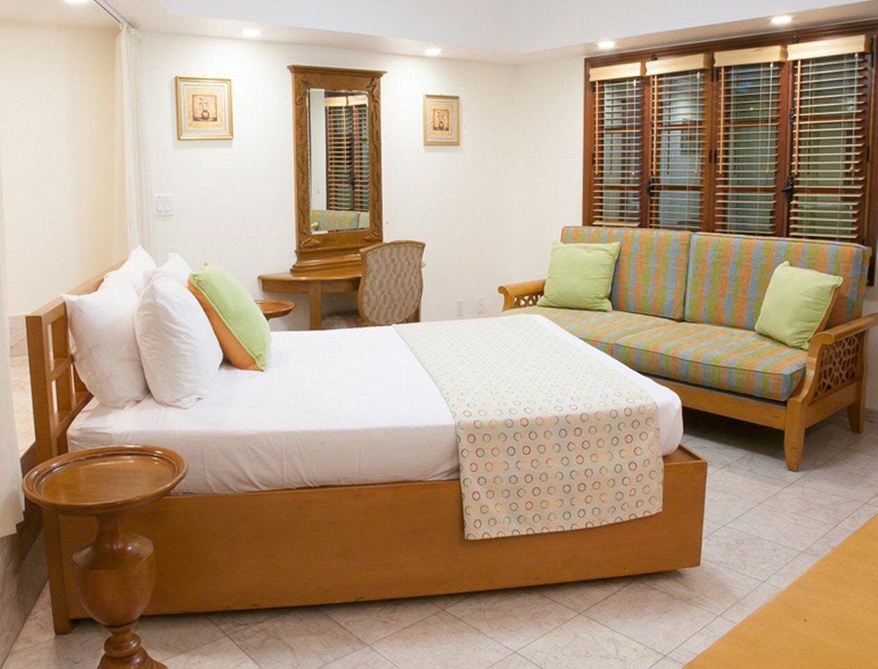 Un dormitorio con cama, sofá, escritorio y silla.
