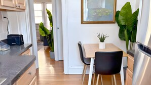 A modern kitchen with wooden cabinets, a built-in oven, and a dining area with a table and chairs. - Perfectly Located 1BR - Hinman D2 (Evanston)