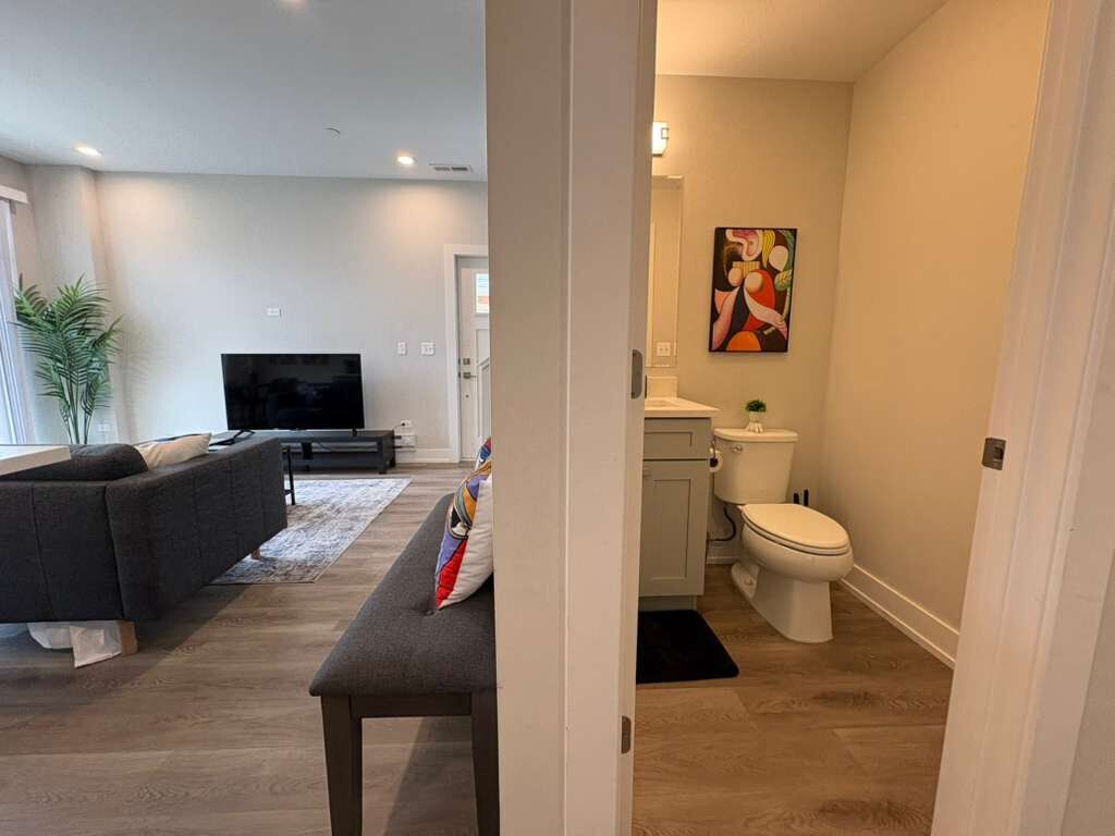 A modern living room with a sofa, a flat-screen TV, and a bench.