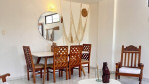 A room with a bed, a round table, and a dining table with chairs. There is a mirror on the wall and a hanging macrame decoration. - Balconee Big Apartment Centre (Santa Marta)