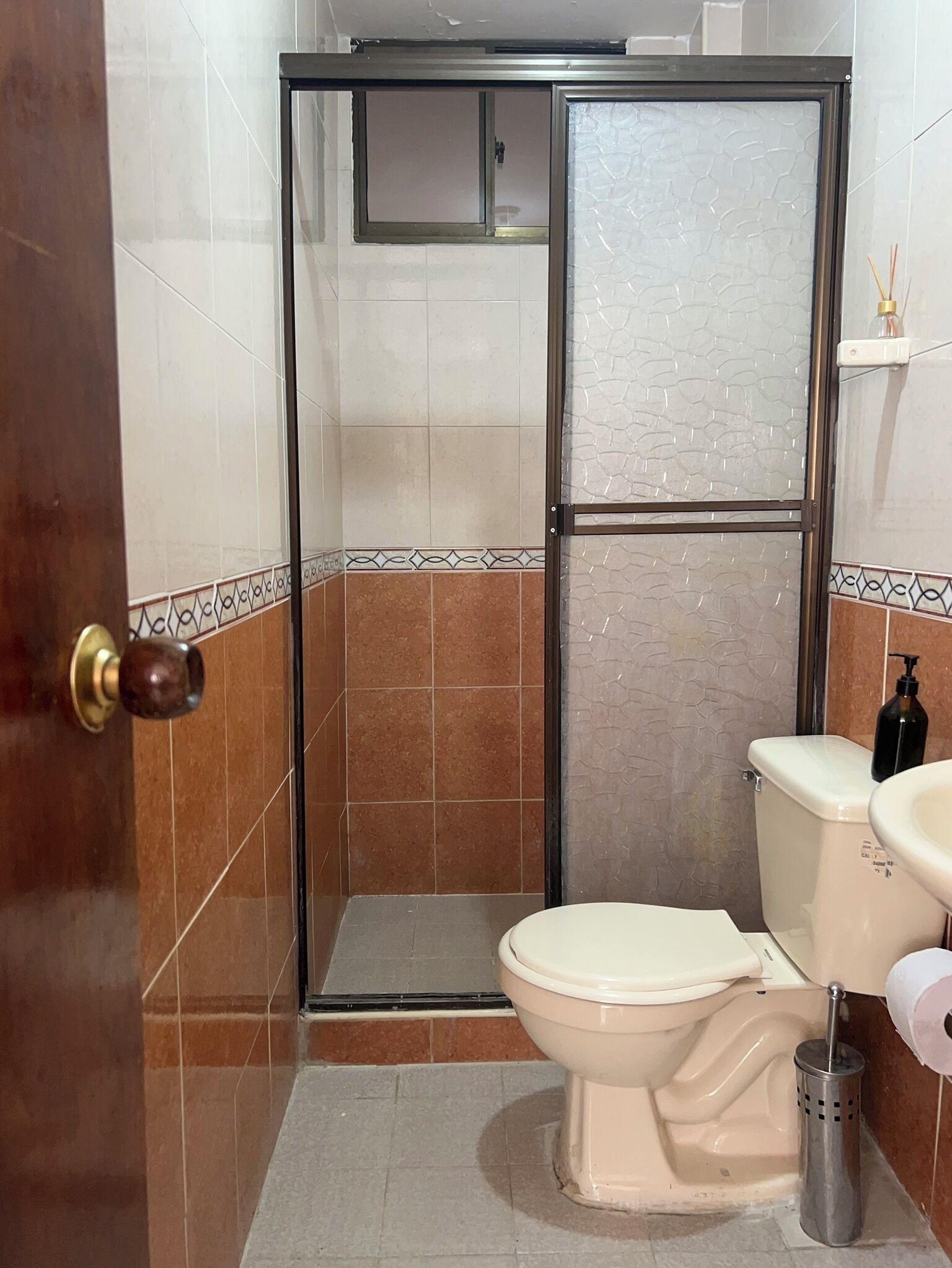 Une salle de bain comprenant des toilettes, un espace douche et un lavabo.