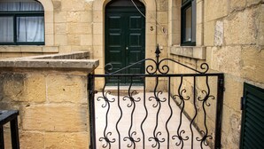 A stone building with a green door, a metal gate, and a number '3' above the door. - ROOFTOP HIDEAWAY, JACUZZI, BBQ & PETss (L-Għarb)