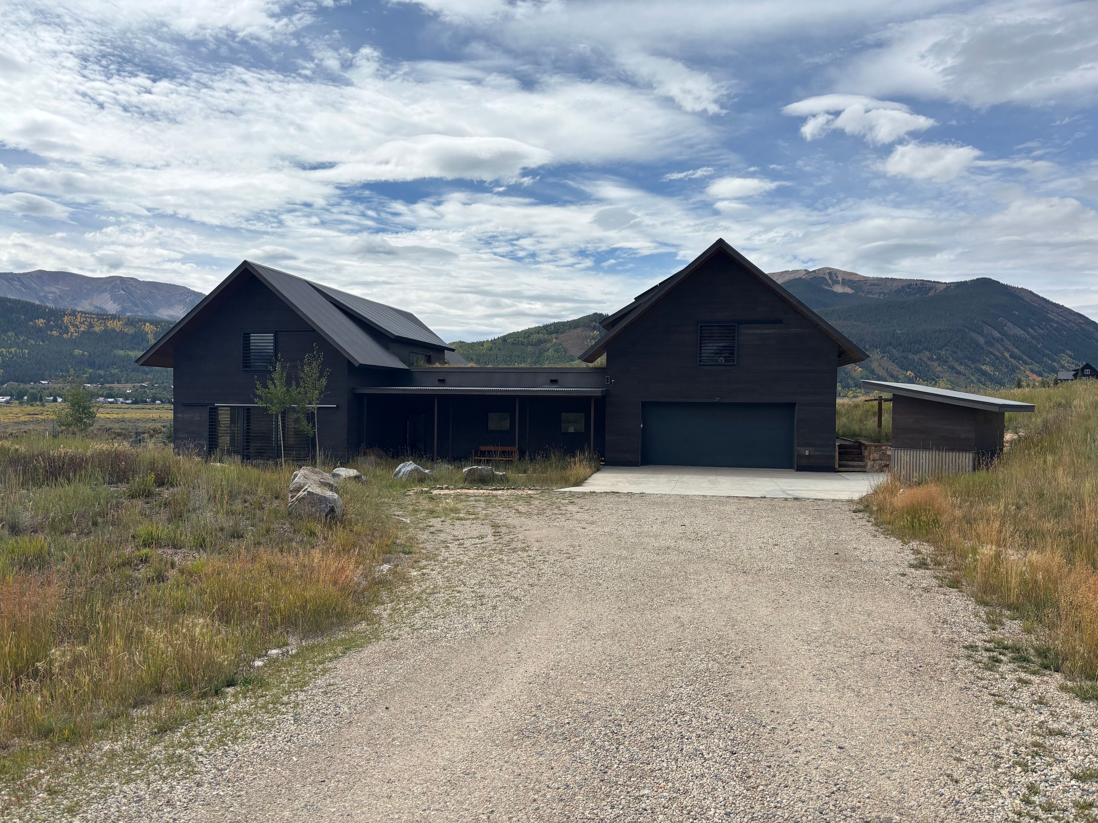 A modern two-story house with a gravel driveway and a large garage.