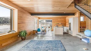 Een modern interieur met houten wanden, een keuken, een eethoek en een trap.