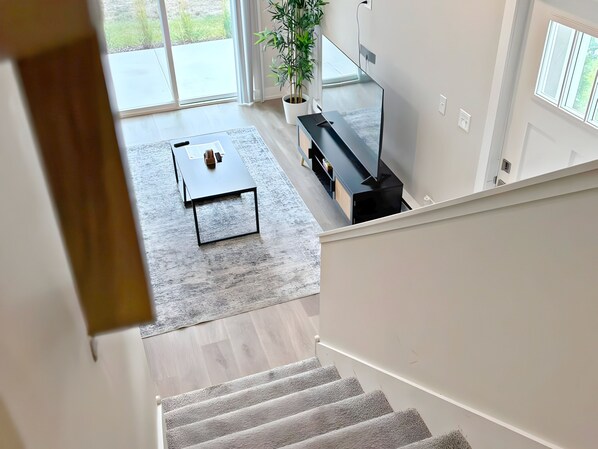 Un salon moderne avec un escalier menant à l’étage supérieur.