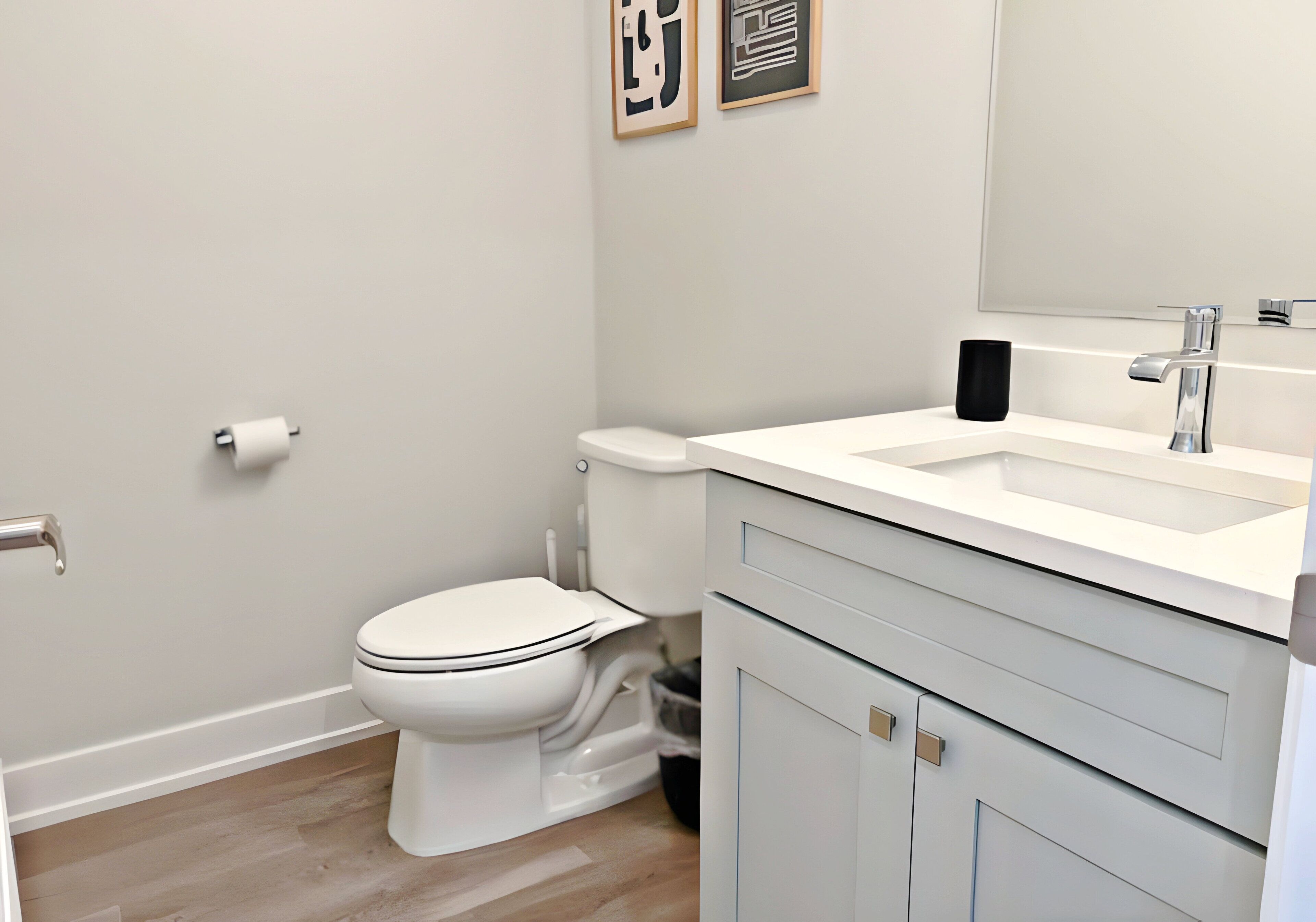 A modern bathroom with a toilet, sink, and mirror.