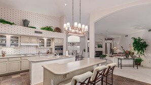 A spacious kitchen with a large island, bar stools, and a dining area with a fireplace.