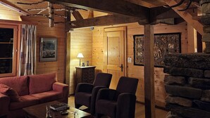 Un intérieur chaleureux avec des poutres en bois, un mur en pierre, une cheminée et un décor rustique.