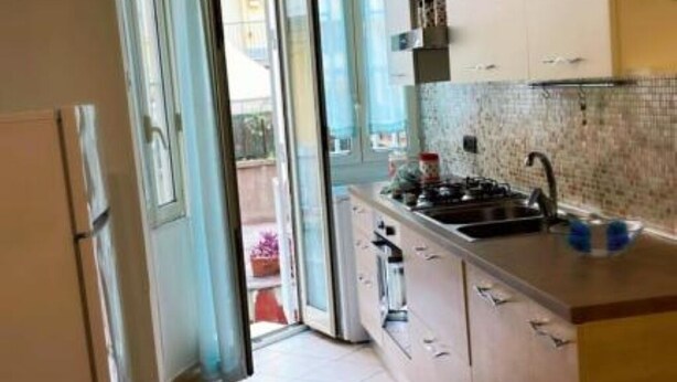 Una cocina moderna con un lavamanos, armarios y una ventana.