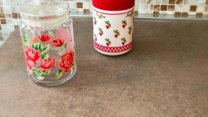 Una encimera de cocina con un tarro de vidrio y una taza de cerámica.
