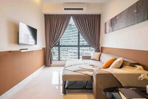 A modern hotel room with a bed, a TV, a window with curtains, and a city view.