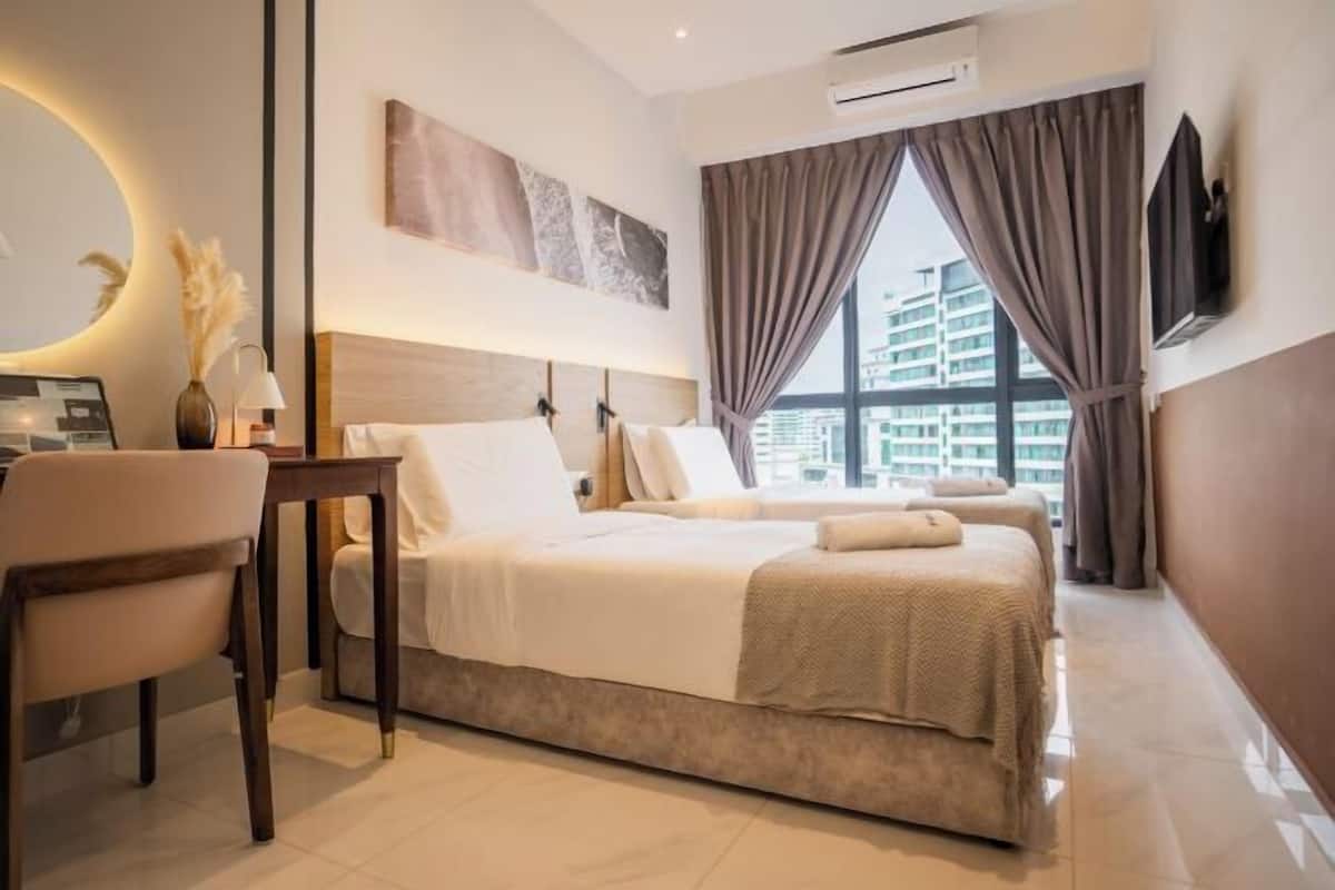 A hotel room with a bed, a desk, a chair, a TV, and a large window with curtains.