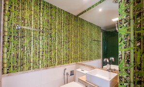A bathroom with bamboo wallpaper, a shower, and two sinks.