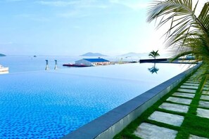 A infinity pool with a clear view of the sea and distant mountains. - Jesselton Quay - Sunset Ocean View Apartments by Quality Home Living (Kota Kinabalu)