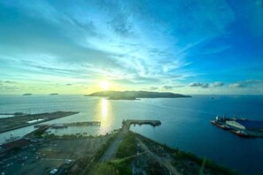 An aerial view of a coastal area with a dock, boats, and a clear sky. - Jesselton Quay - Sunset Ocean View Apartments by Quality Home Living (Kota Kinabalu)