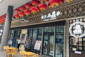 Un restaurant à l’architecture de style chinois traditionnel, avec des lanternes rouges et une enseigne ornée de caractères chinois.