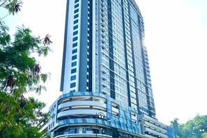 A tall, modern building with multiple balconies and a curved facade. - Jesselton Quay - Sunset Ocean View Apartments by Quality Home Living (Kota Kinabalu)