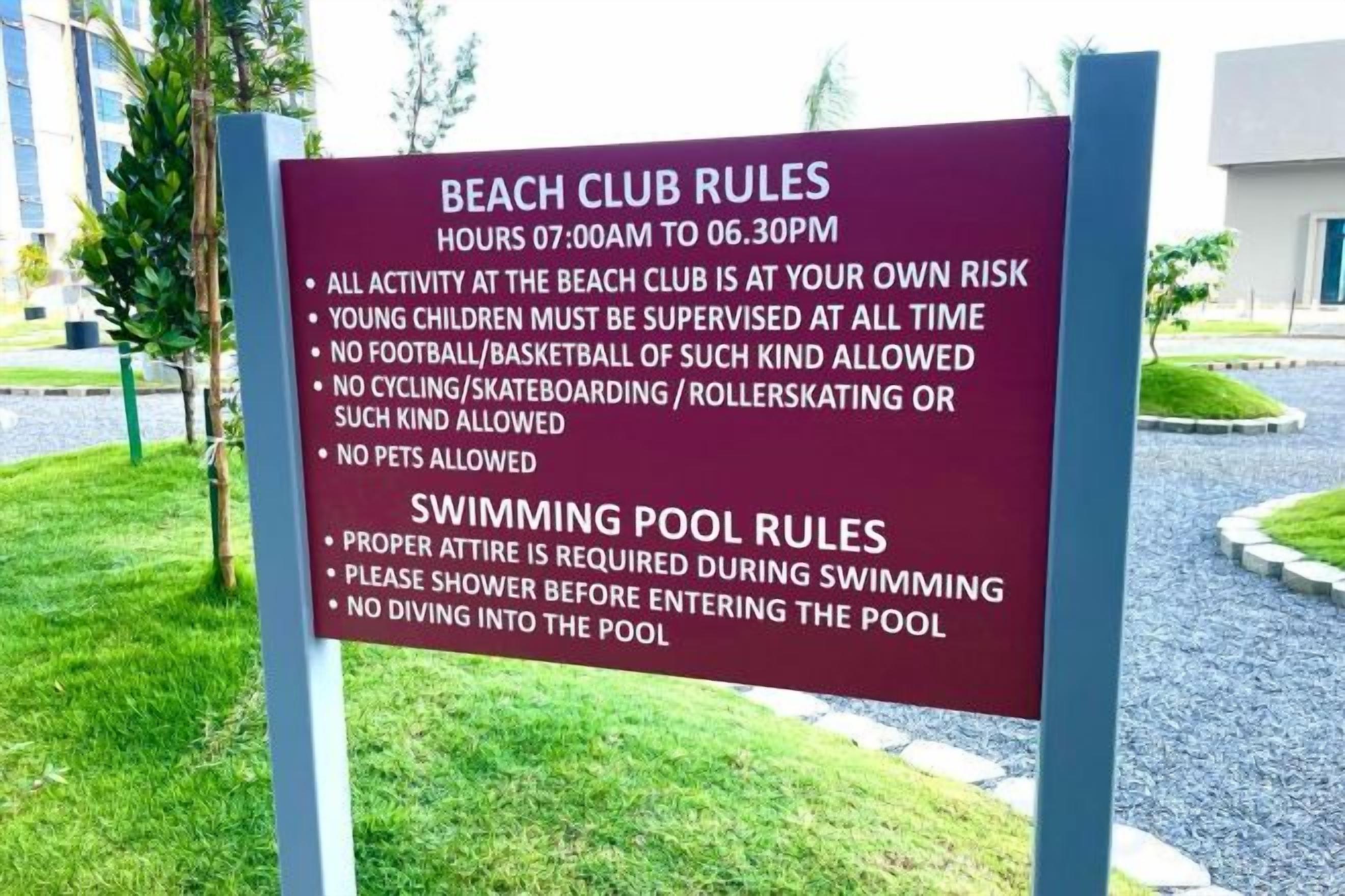 Placa com regras do clube de praia e da piscina.