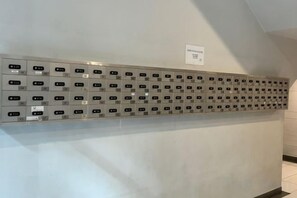 A row of metallic lockers with numbers on them, mounted on a wall. - Jesselton Quay - Sunset Ocean View Apartments by Quality Home Living (Kota Kinabalu)
