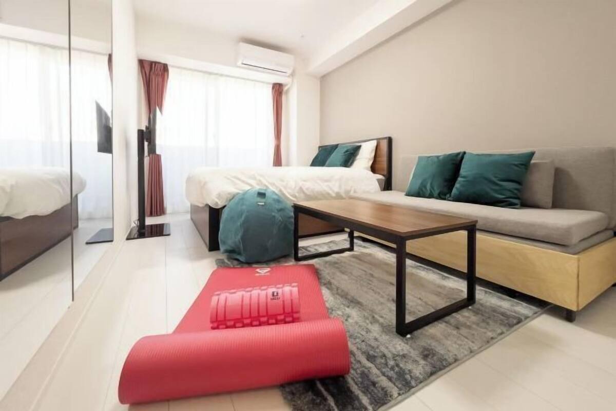 Une chambre d’hôtel moderne équipée d’un lit, d’un canapé, d’une table basse et d’appareils de musculation.