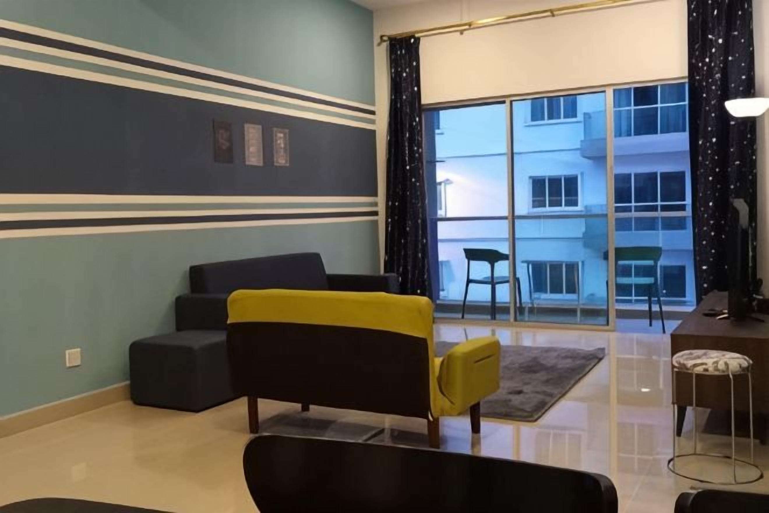 A living room with a sofa, a yellow chair, a dining table, and a view of a building through a glass door.