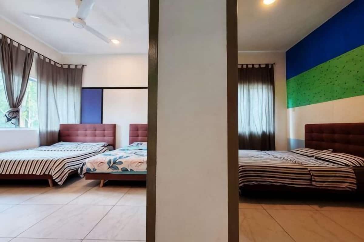 A hotel room with two beds, a ceiling fan, and a large window with curtains.