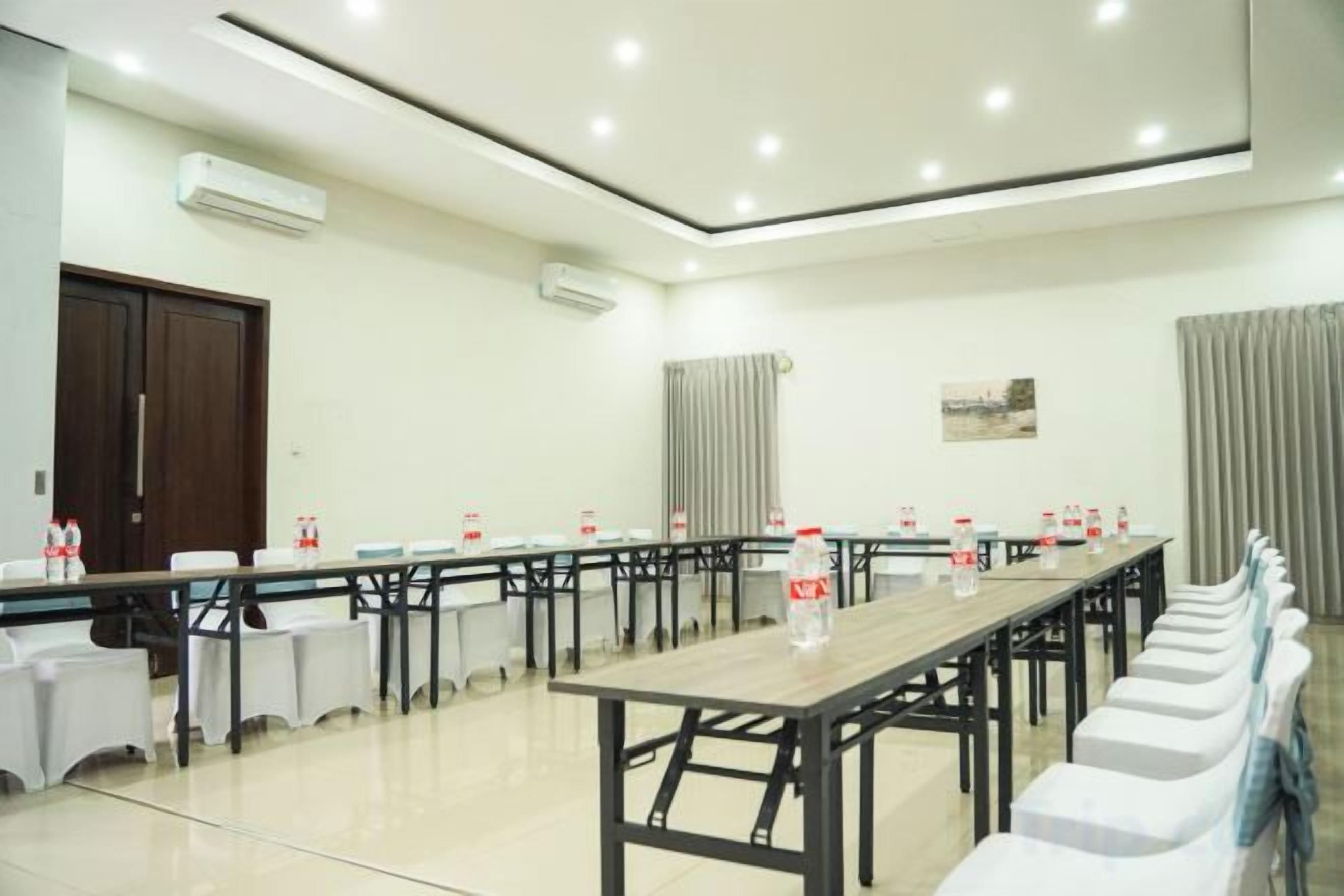 A conference room with a long table, chairs, and a whiteboard.