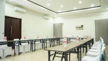 A conference room with a long table, chairs, and a whiteboard.