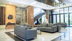 A spacious lobby with modern furniture, a staircase, and large windows. - Long Beach Hotel Pangandaran (Pangandaran)