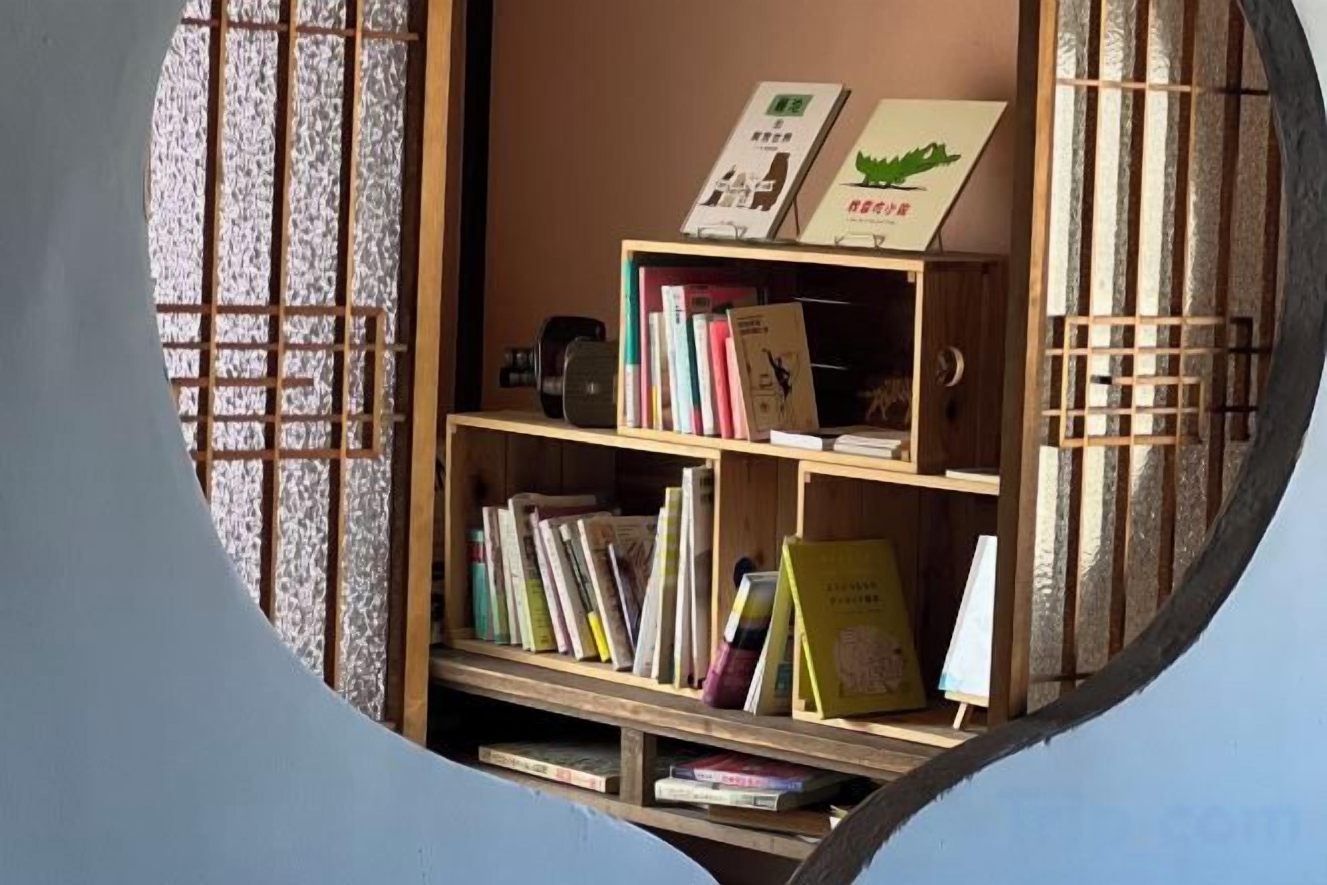 Vista circolare di una stanza con una libreria in legno piena di libri e una piccola lavagna.