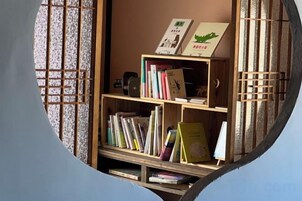 Vista circular de una habitación con una estantería de madera llena de libros y una pequeña pizarra.
